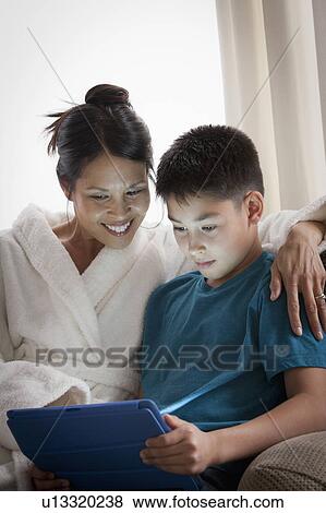 Stock Photo - Mother embracing son using laptop. Fotosearch