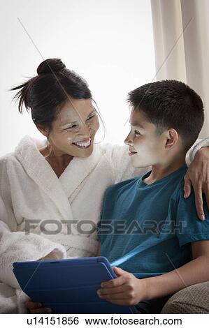Stock Photograph - Mother embracing son using laptop. Fotosearch