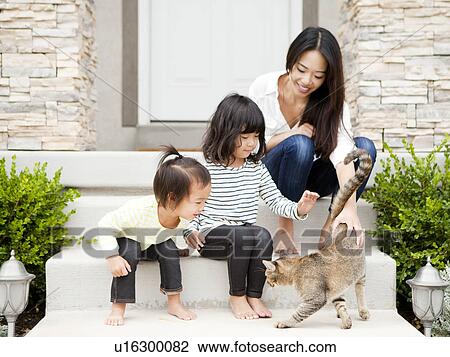 Mother sitting on doorsteps with two daughters (2-3, 4-5) and playing with cat View Large Photo Image Stock Image - Mother sitting on doorsteps with two daughters (2-3, 4-5) and playing with cat. Fotosearch