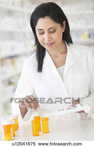 Stock Photography - Pharmacist preparing medicines. Fotosearch