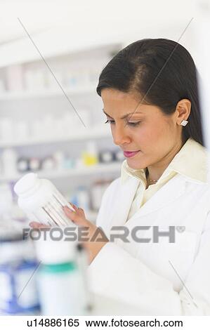 Pharmacist reading label on medicine bottle View Large Photo Image Stock Photography - Pharmacist reading label on medicine bottle. Fotosearch