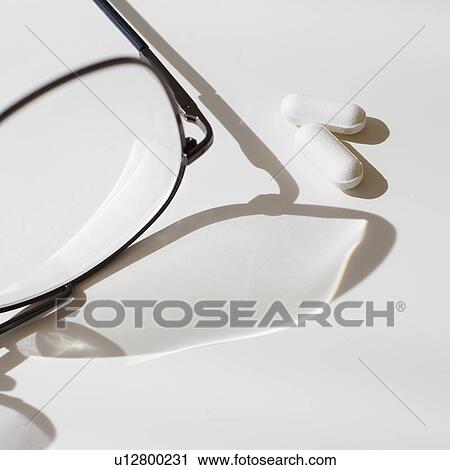 Stock Image - Pills and eyeglasses, studio shot. Fotosearch