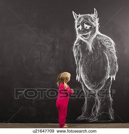 Stock Photo - Portrait of baby girl (18-23 months) in front of huge monster drawn on blackboard. Fotosearch