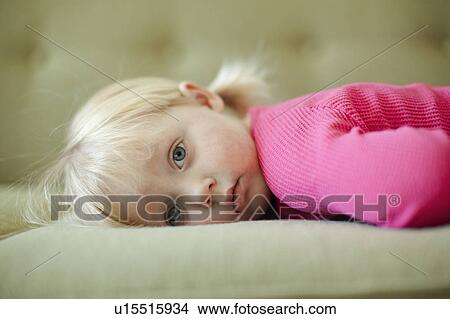 Portrait of baby girl (18-23 months) resting on sofa View Large Photo Image Picture - Portrait of baby girl (18-23 months) resting on sofa. Fotosearch