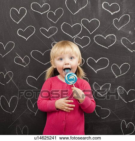 Portrait of baby girl (18-23 months) eating lollipop View Large Photo Image Stock Image - Portrait of baby girl (18-23 months) eating lollipop. Fotosearch