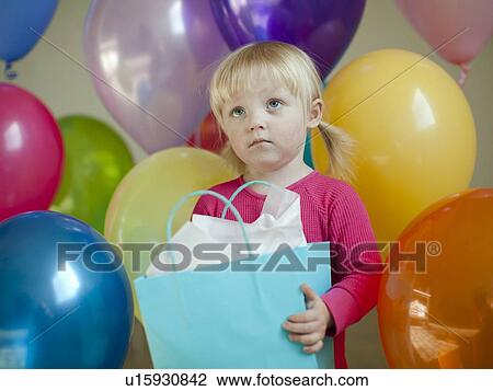 Stock Image - Portrait of baby girl (18-23 months) wit colorful balloons. Fotosearch