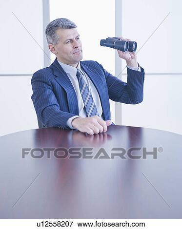 Portrait of businessman holding binoculars View Large Photo Image Stock Photo - Portrait of businessman holding binoculars. Fotosearch