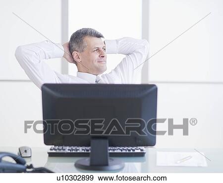 Stock Photo - Portrait of businessman relaxing at desk. Fotosearch
