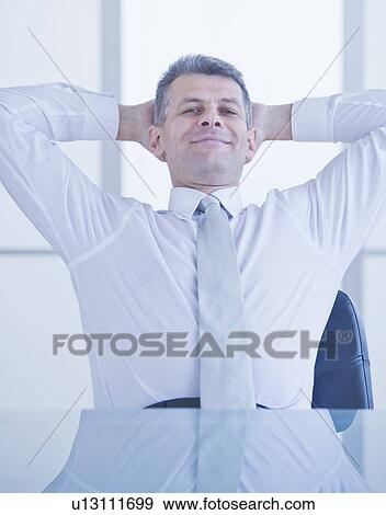 Stock Photo - Portrait of businessman relaxing at desk. Fotosearch
