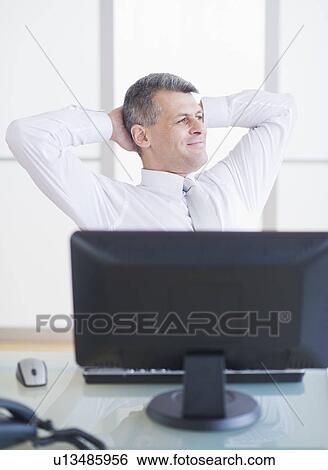 Portrait of businessman relaxing at desk View Large Photo Image Stock Photograph - Portrait of businessman relaxing at desk. Fotosearch