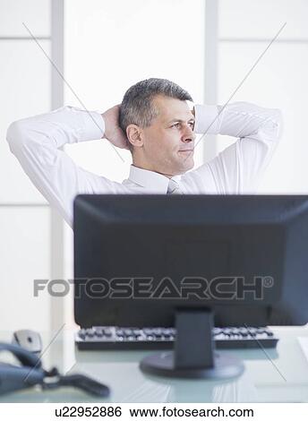 Portrait of businessman relaxing at desk View Large Photo Image Stock Photograph - Portrait of businessman relaxing at desk. Fotosearch