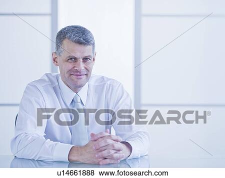 Portrait of businessman sitting at desk View Large Photo Image Stock Photo - Portrait of businessman sitting at desk. Fotosearch