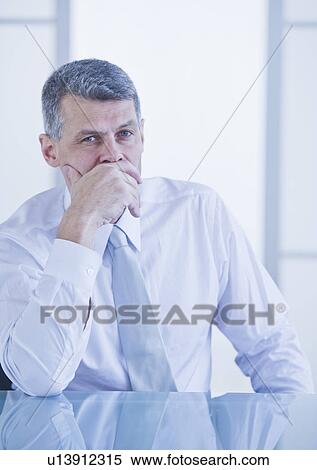Stock Photography - Portrait of businessman sitting at desk. Fotosearch