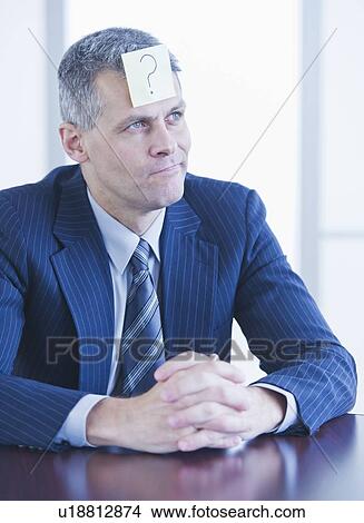 Picture - Portrait of businessman with label on forehead. Fotosearch