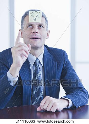 Stock Image - Portrait of businessman with label on forehead. Fotosearch