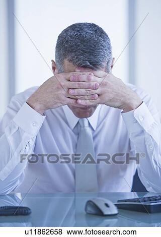 Portrait of depressed businessman sitting at desk View Large Photo Image Stock Photo - Portrait of depressed businessman sitting at desk. Fotosearch
