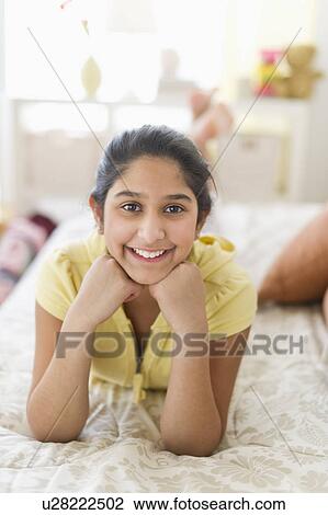 Portrait of girl (12-13) lying on bed View Large Photo Image Stock Image - Portrait of girl (12-13) lying on bed. Fotosearch
