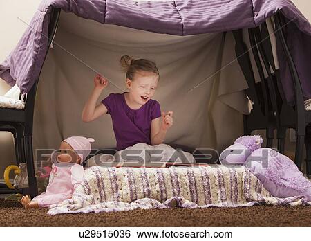 Stock Photograph - Portrait of happy girl (4-5) in playhouse. Fotosearch