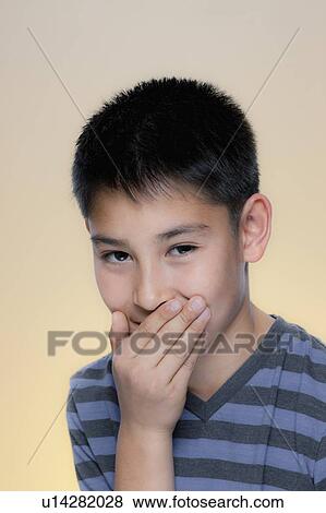 Portrait of laughing boy covering mouth with hand View Large Photo Image Stock Photo - Portrait of laughing boy covering mouth with hand. Fotosearch