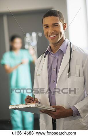 Stock Image - Portrait of male doctor in hallway. Fotosearch