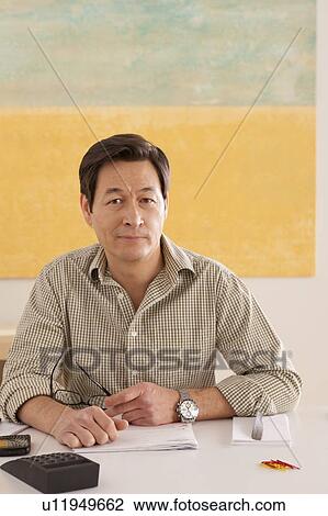 Portrait of man doing paperwork View Large Photo Image Stock Image - Portrait of man doing paperwork. Fotosearch