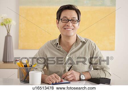 Portrait of man doing paperwork View Large Photo Image Stock Photo - Portrait of man doing paperwork. Fotosearch