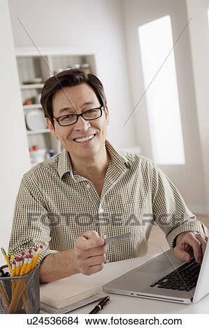 Portrait of man shopping online from home View Large Photo Image Picture - Portrait of man shopping online from home. Fotosearch