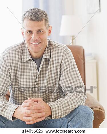 Portrait of man sitting in living room View Large Photo Image Stock Photography - Portrait of man sitting in living room. Fotosearch