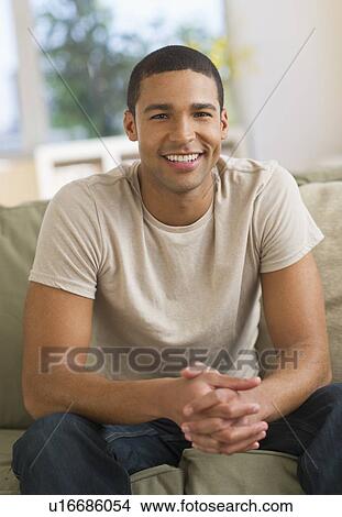 Portrait of man sitting on sofa View Large Photo Image Picture - Portrait of man sitting on sofa. Fotosearch