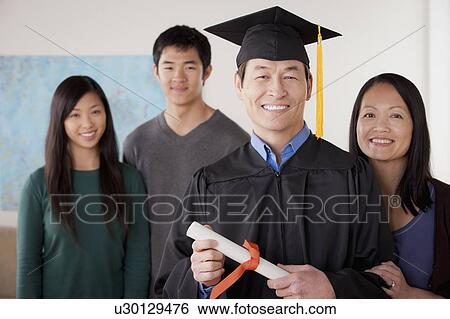 Portrait of mature man in graduation gown with family View Large Photo Image Stock Photograph - Portrait of mature man in graduation gown with family. Fotosearch