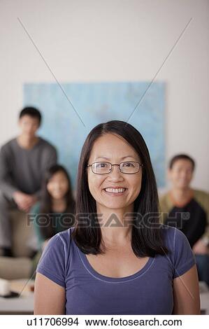 Picture - Portrait of mature woman with family in background. Fotosearch
