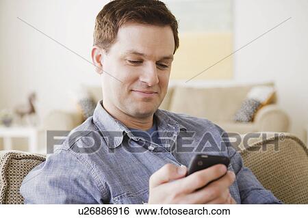Stock Photograph - Portrait of mid adult man using mobile phone. Fotosearch