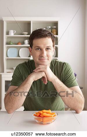 Portrait of mid adult man with bowl of carrots View Large Photo Image Stock Photo - Portrait of mid adult man with bowl of carrots. Fotosearch