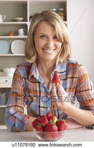 Portrait of mid adult woman with bowl of strawberries View Large Photo Image Stock Image - Portrait of mid adult woman with bowl of strawberries. Fotosearch