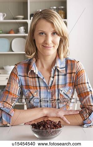 Stock Image - Portrait of mid adult woman with bowl of strawberries. Fotosearch