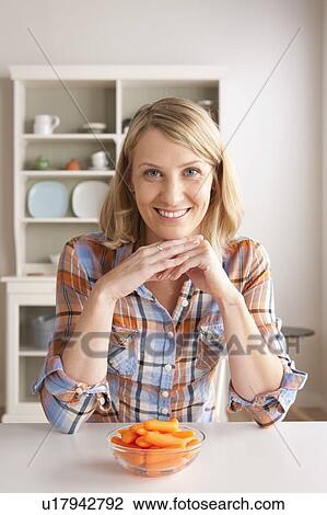 Portrait of mid adult woman with bowl of carrots View Large Photo Image Stock Image - Portrait of mid adult woman with bowl of carrots. Fotosearch