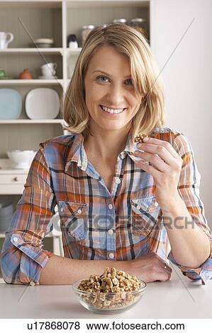 Portrait of mid adult woman with bowl of walnuts View Large Photo Image Stock Photo - Portrait of mid adult woman with bowl of walnuts. Fotosearch
