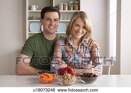 Stock Photo - Portrait of mid adult woman with healthy fruits. Fotosearch