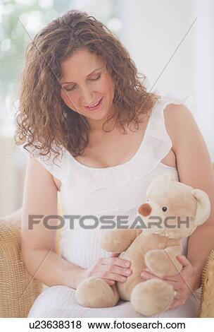Stock Photo - Portrait of pregnant woman with teddy bear. Fotosearch