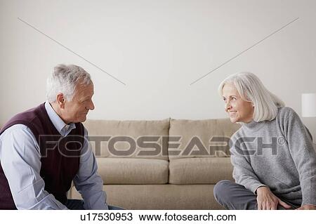 Stock Image - Portrait of senior couple sitting on sofa. Fotosearch
