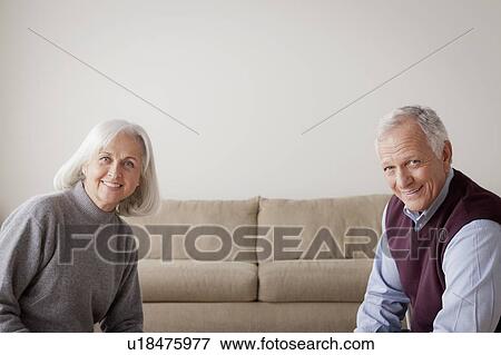 Stock Photo - Portrait of senior couple sitting on sofa. Fotosearch