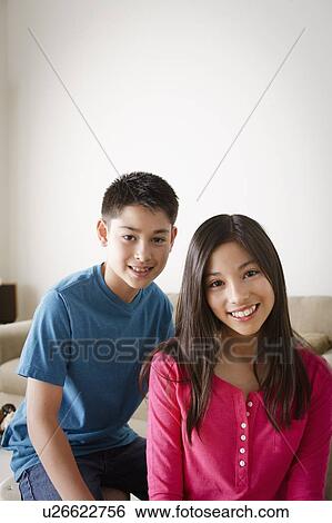 Stock Photograph - Portrait of smiling brother (10-11) and sister (12-13). Fotosearch