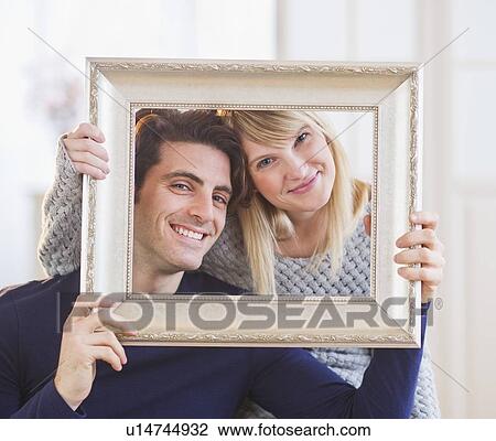 Portrait of smiling couple holding picture frame View Large Photo Image Stock Image - Portrait of smiling couple holding picture frame. Fotosearch