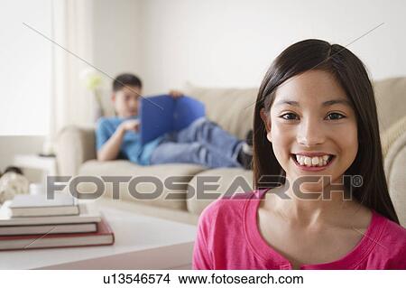 Portrait of smiling girl (12-13), brother (10-11) in background View Large Photo Image Picture - Portrait of smiling girl (12-13), brother (10-11) in background. Fotosearch