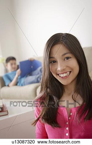 Portrait of smiling girl (12-13), brother (10-11) in background View Large Photo Image Stock Image - Portrait of smiling girl (12-13), brother (10-11) in background. Fotosearch