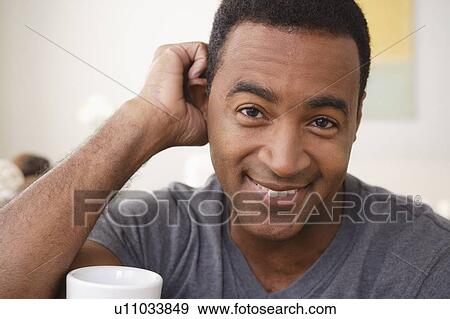 Stock Photo - Portrait of smiling mature man holding mug. Fotosearch