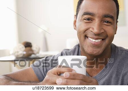 Stock Photo - Portrait of smiling mature man holding mug. Fotosearch