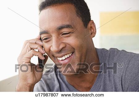 Stock Photo - Portrait of smiling mature man talking via mobile . Fotosearch