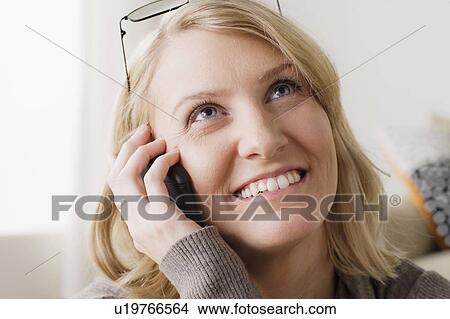 Portrait of smiling mid adult woman talking via mobile View Large Photo Image Picture - Portrait of smiling mid adult woman talking via mobile. Fotosearch