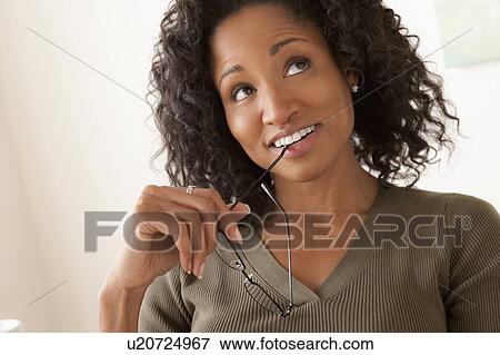 Portrait of smiling mid adult woman holding glasses View Large Photo Image Stock Photo - Portrait of smiling mid adult woman holding glasses. Fotosearch